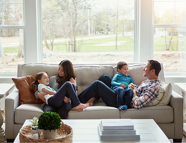 Family of four sitting on the couch in their living room