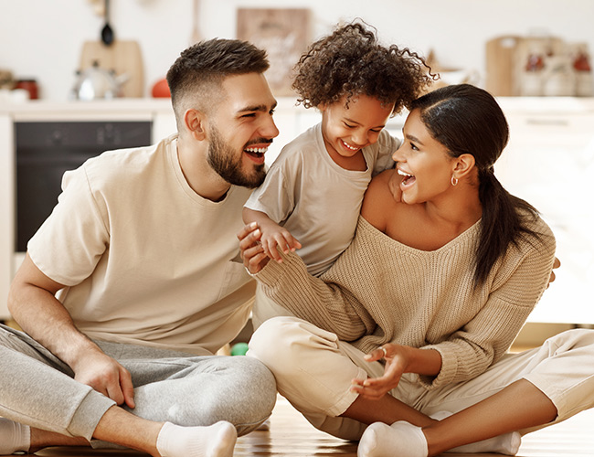 family sitting together on the floor of their condo