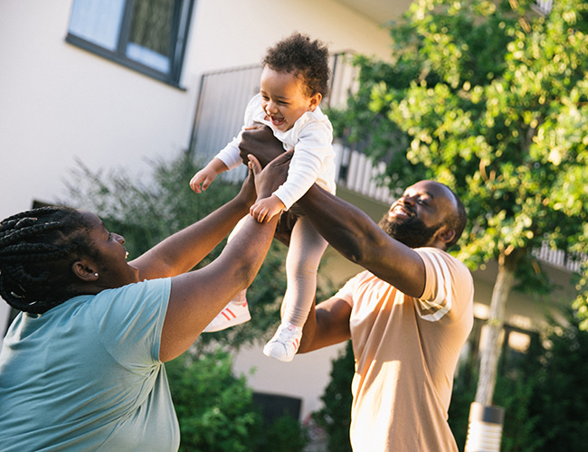 Family playing with their toddler outside of their townhome