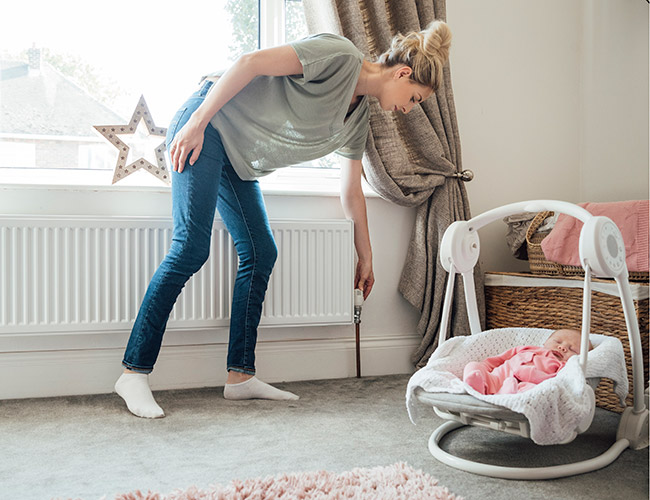 Woman adjusting the room's temperature 