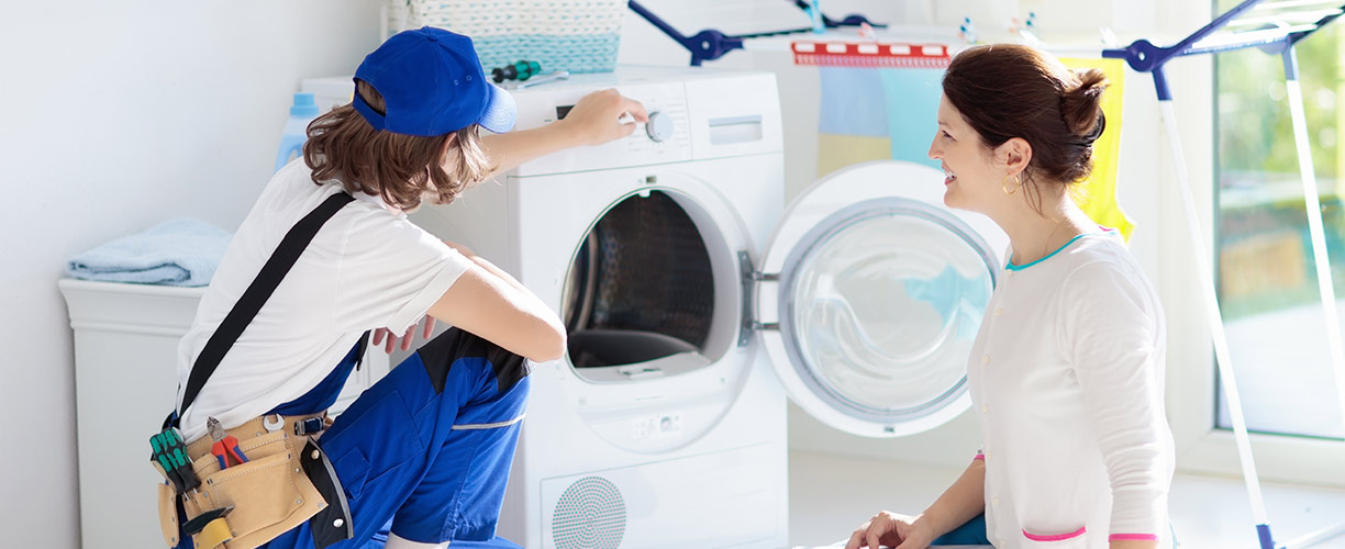 Repair person showing a homeowner an issue with dryer.