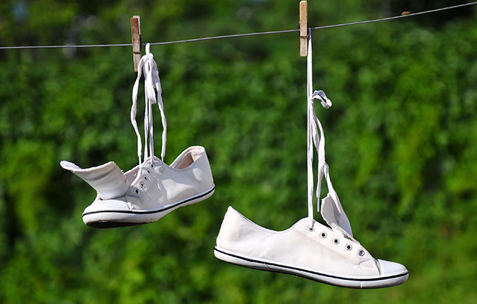 White sneakers hung up to dry on a clothesline
