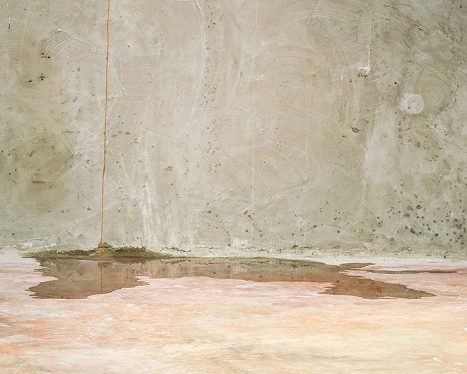 Water leaks through a crack in a basement foundation.