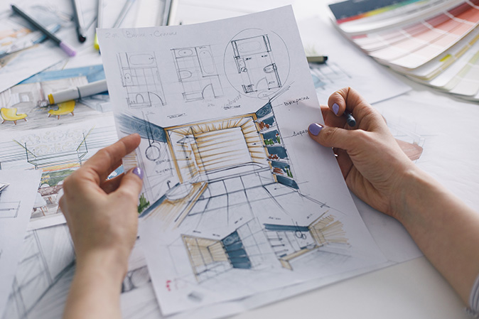 A person holding a sheet of paper with a concept for a bathroom renovation on it.