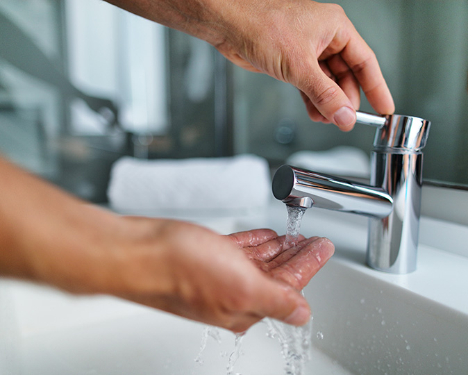 A man checks the functionality of a bathroom sink.