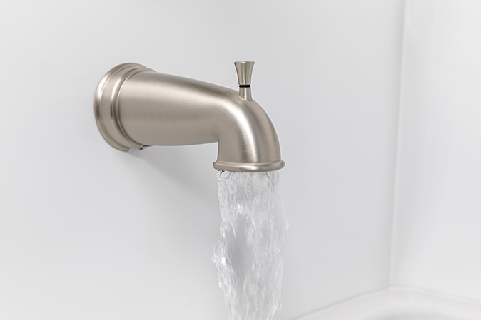 Water flows through a bathtub spout with the diverter in the “down” position.