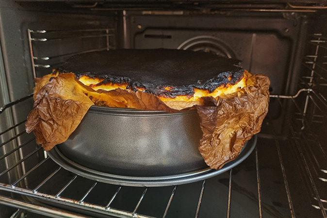 A burnt souffle overflowing its pan in a residential oven.