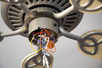 Ceiling fan with visible wires in housing