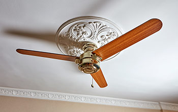 Ceiling fan with a white, ornate ceiling medallion