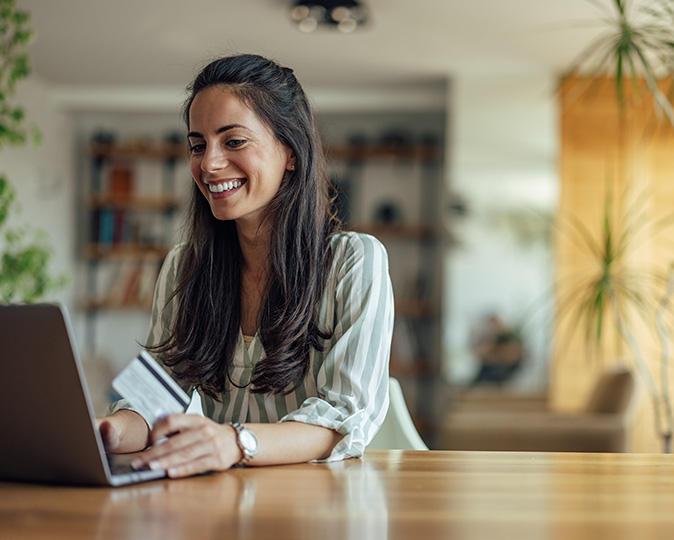  A woman looks at her credit report on a laptop in her home. 