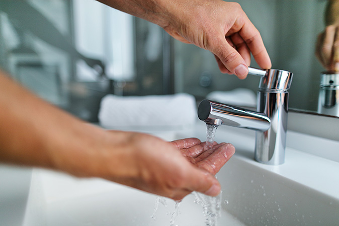 A man checking the hot water temperature.