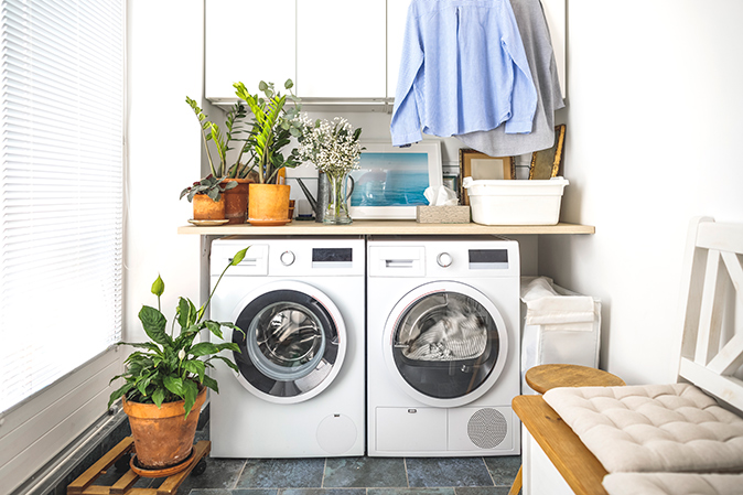 Side-by-side white washer and dryer set in a laundry room