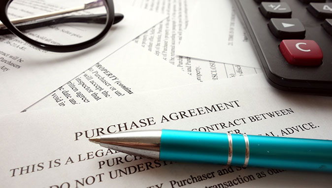 A home warranty contract sits on a desk awaiting signatures.