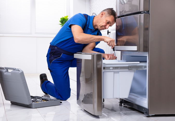 A technician repairing a refrigerator.
