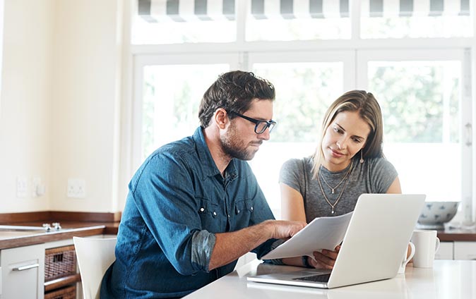 Couple looking over paperwork in their kitchen 