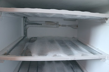 Closeup image of freezer with frost covering shelves