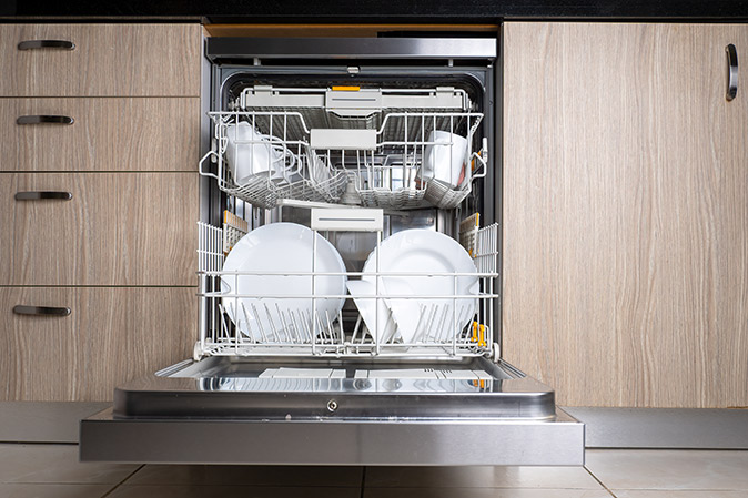 The image shows a dishwasher with racks extended.
