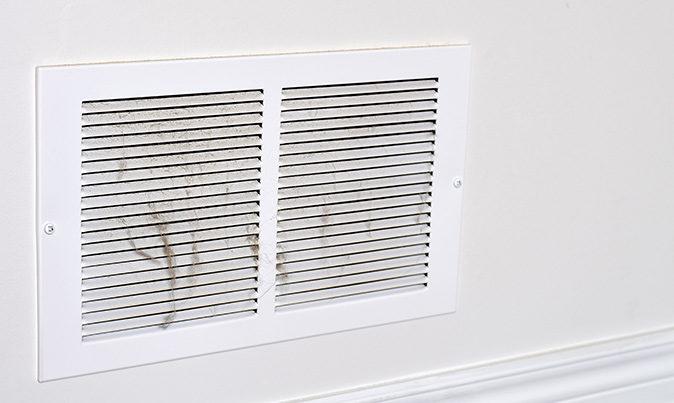 A dusty air vent cover, revealing accumulated dirt and debris.