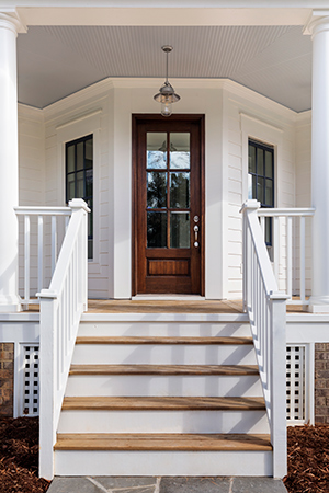 Beautiful new wood exterior door on classic-looking front porch.