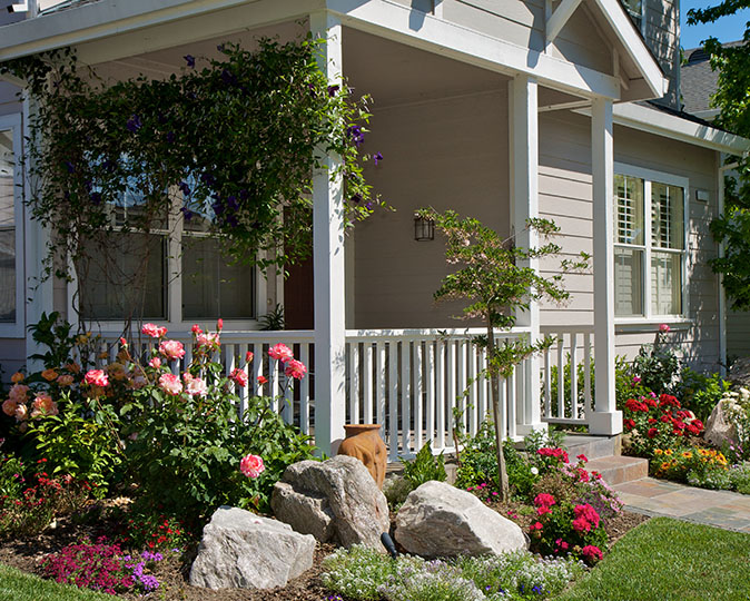 New landscaping and flowers surround front porch of home.