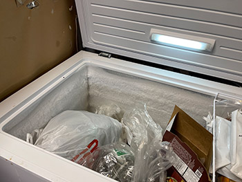 Closeup of frozen packaged foods packed into in chest freezer