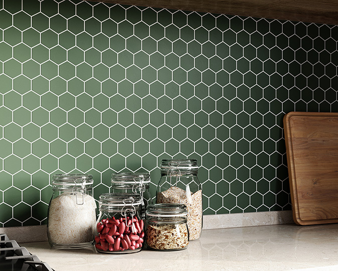 Green honeycomb-shaped backsplash tiles with colorful spices.