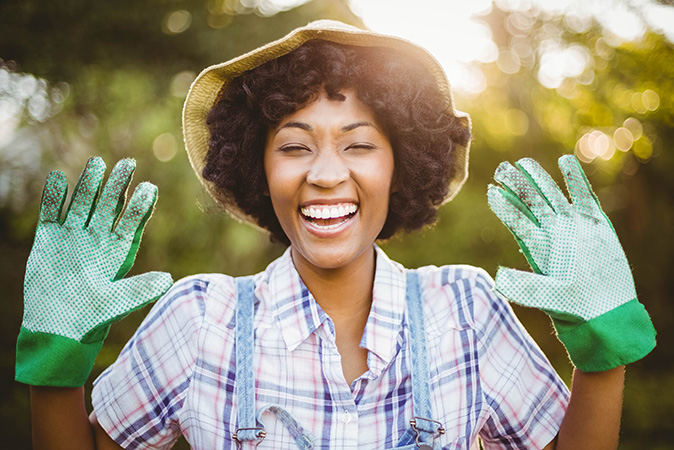 Smiling gardener outside on sunny day working in her garden.