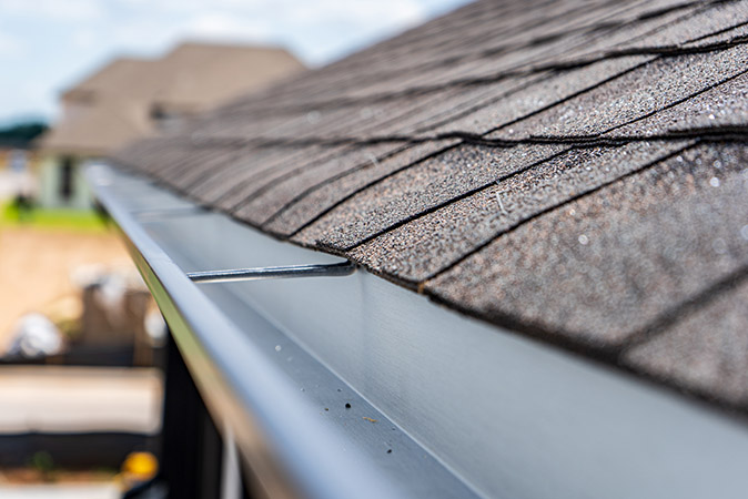 Closeup image of a gutter installed to the fascia of a home.