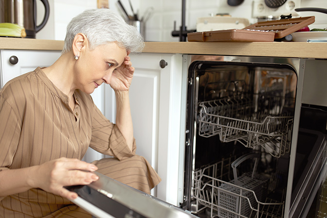  A homeowner realizes she needs help fixing her dishwasher door.
