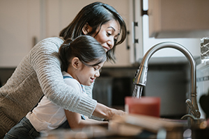 Mom and daughter using faucet
