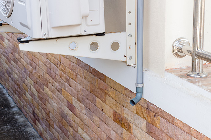 Condensate drain line outside home carries away condensation for central air conditioners.