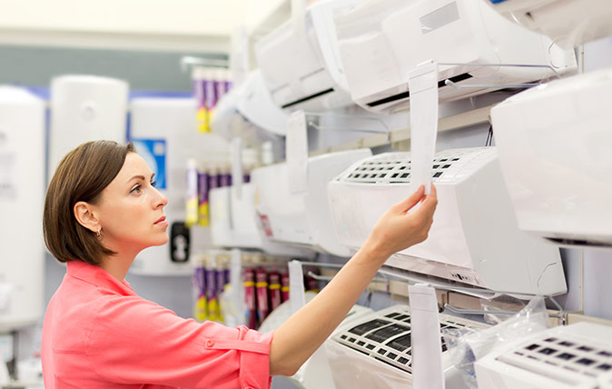 Woman comparing different HVAC units in a store