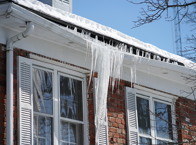 Icicles form on a home’s gutter causing damage to the gutter system and soffit.