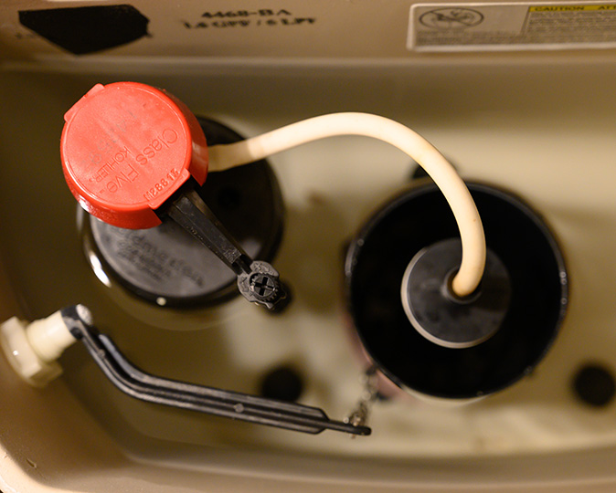 Looking down into a toilet tank filled with water and a raised float.
