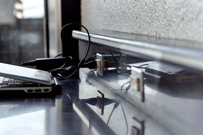 A laptop at a charging station on top of a desk in a home office.