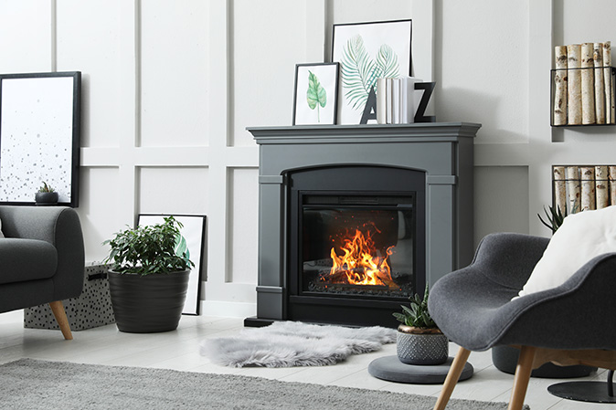 A living room interior with an electric fireplace burning.