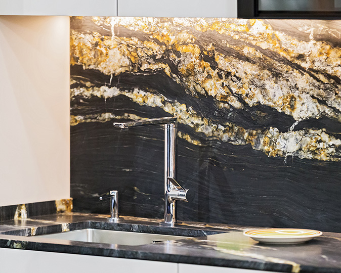 Beautiful modern kitchen design, kitchen faucet, black and gold stone marble countertop kitchen.