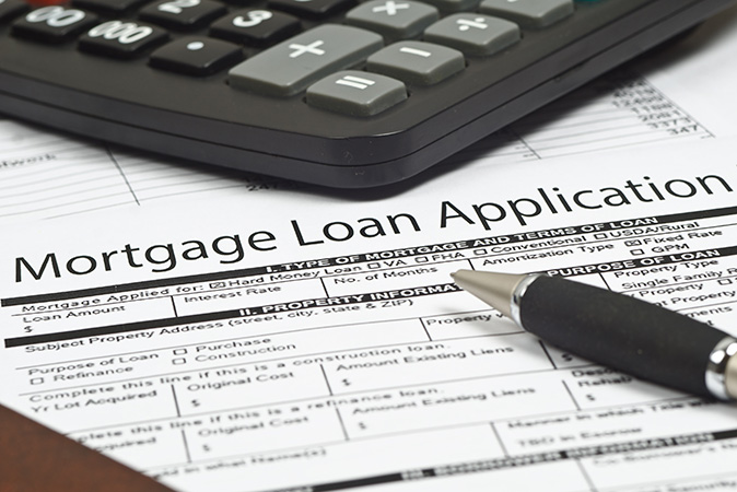 Close-up of a typical mortgage loan application form and pen on a desk.