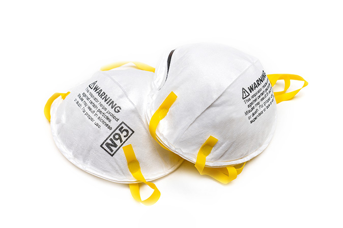 Two N-95 masks sit overlapping each other set against a white background.