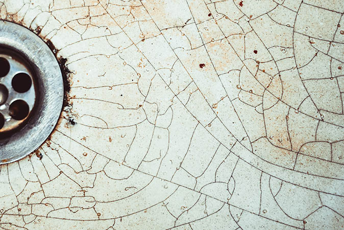 Image of damaged tub shows pattern of cracks.