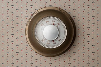 Analog thermostat on wallpapered wall