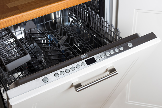 Image shows top rack and interior wall of a clean dishwasher 