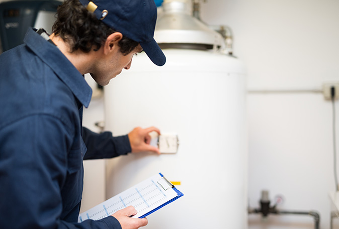 A plumber repairing a water heater in a house.
