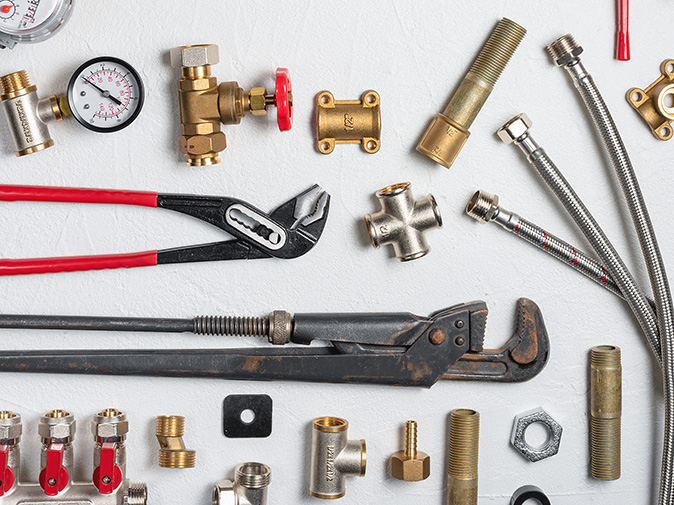 An array of assorted tools used in plumbing projects set against a white background.