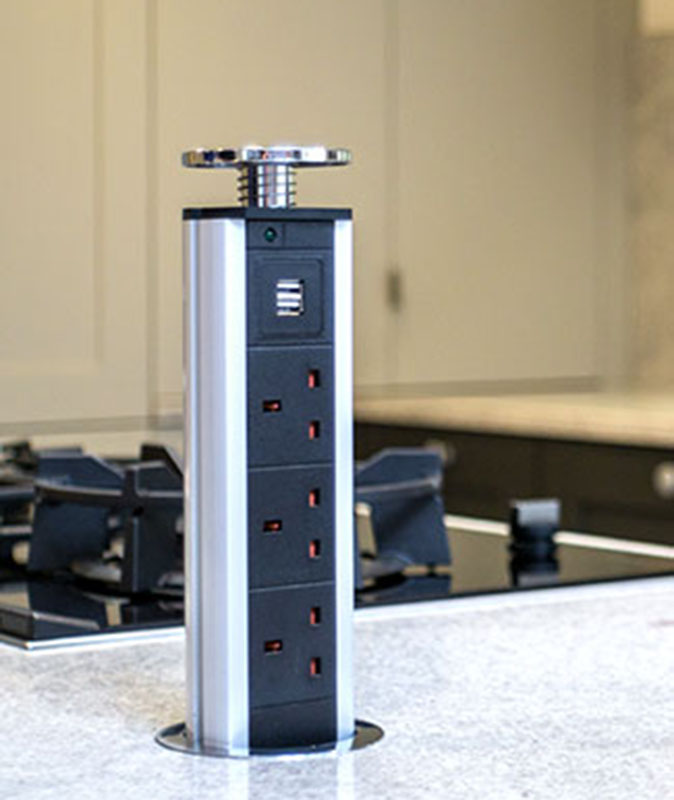 A pop-up outlet bank with traditional and USB outlets protrudes from a kitchen countertop.