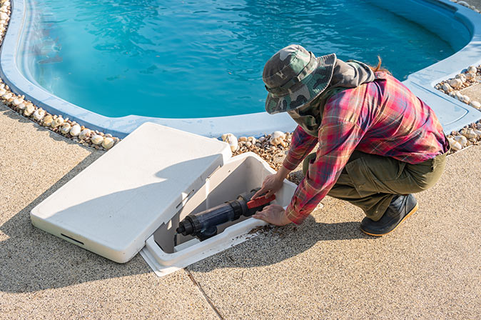 A technician fixing a pool pump.