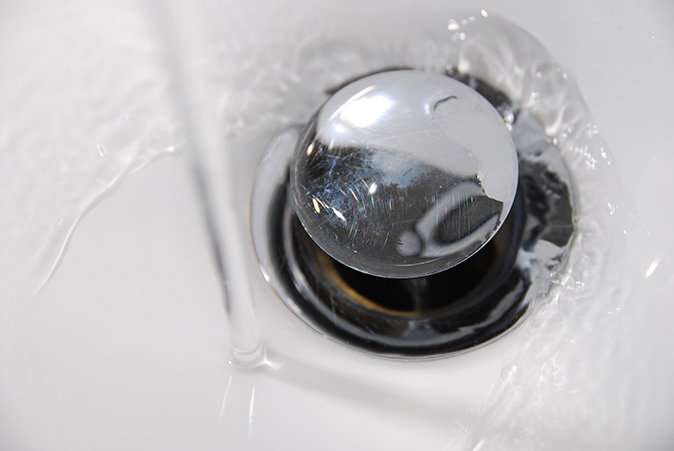 A pop-up sink stopper in a bathroom sink. 