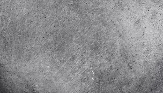 Close-up of a lightly scratched stainless steel surface.