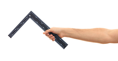 Hand holding a square tool reinforcing Square Foot Rule and home repair saving