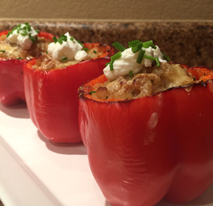 Image shows bright red stuffed peppers filled with Thanksgiving leftovers.